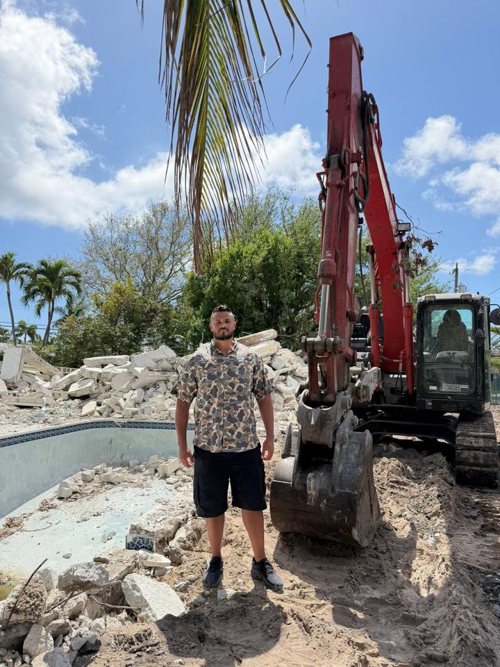 Adrian Carvalho em obra com máquina escavadeira